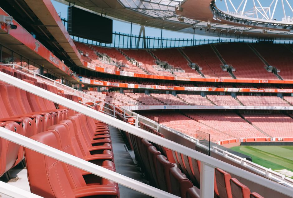 View of empty red seats and modern architecture at Emirates Stadium, London.