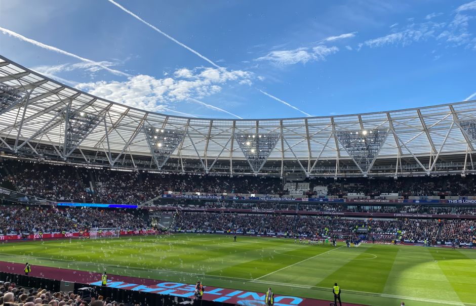A packed London Stadium hosts a thrilling soccer match, with vibrant atmosphere and engaged crowd.